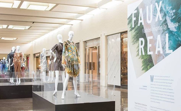 Exhibition plinth with text and platforms with highly patterned women's garments