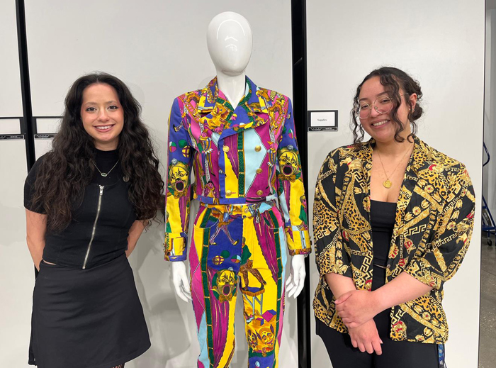 Students standing next to a dressed mannequin.