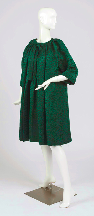 White mannequin turned to an angle showing a dark green and black voluminous knee-length coat and dress